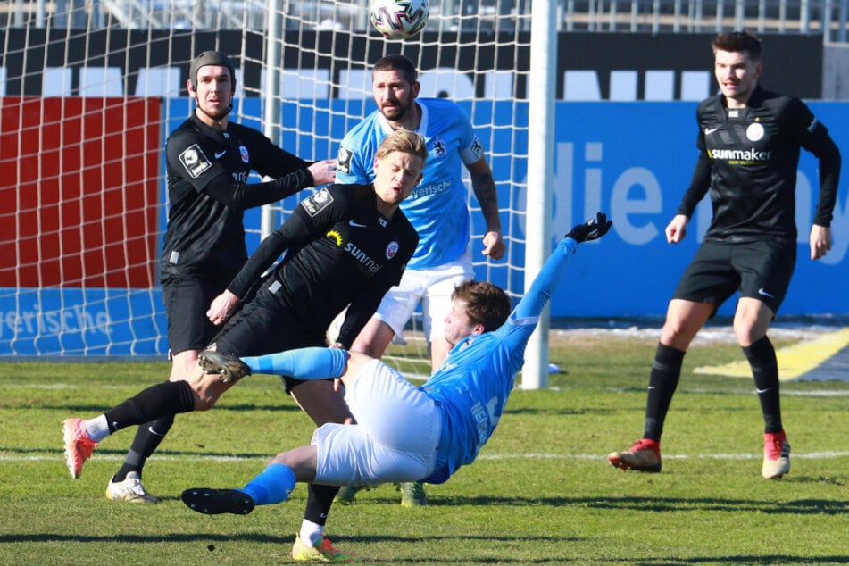 Richard Neudecker (vorn) und Sascha Mölders (M, hinten) von den Löwen kämpfen gegen die Rostocker Damian Roßbach (l.) und Nico Neidhart um den Ball.