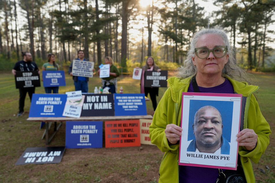 Cathy Harmon-Christian, the executive director of Georgians for Alternatives to the Death Penalty, holds a photo of Willie Pye outside of the Georgia Diagnostic Prison in Jackson.