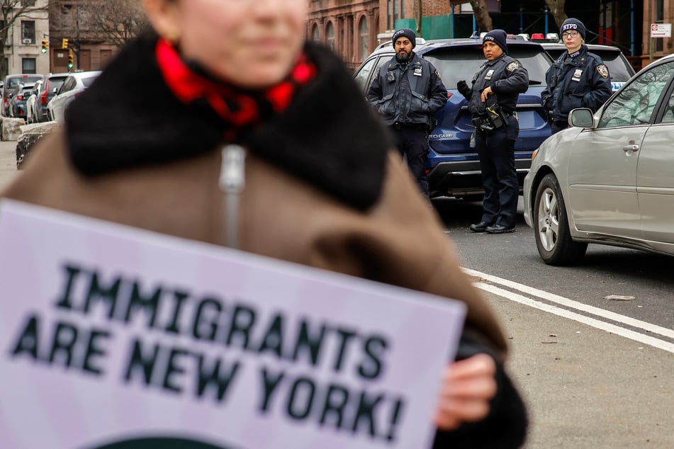 NYPD officers watch demonstrators as they take rally against Trump's anti-immigrant agenda in New York City on January 18, 2025.