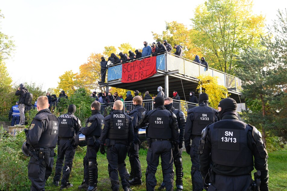 Polizisten und Aktivisten stehen während einer Durchsuchung eines besetzten Hauses im Pauli Park.