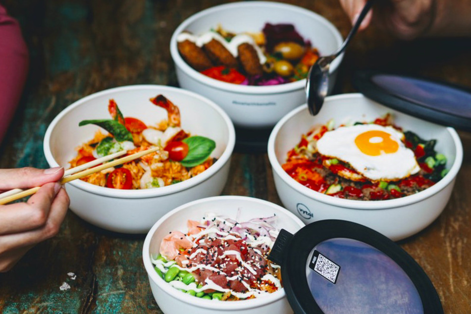 Mehrere Personen essen aus Mehrwegschalen des Kölner Start-ups Vytal.
