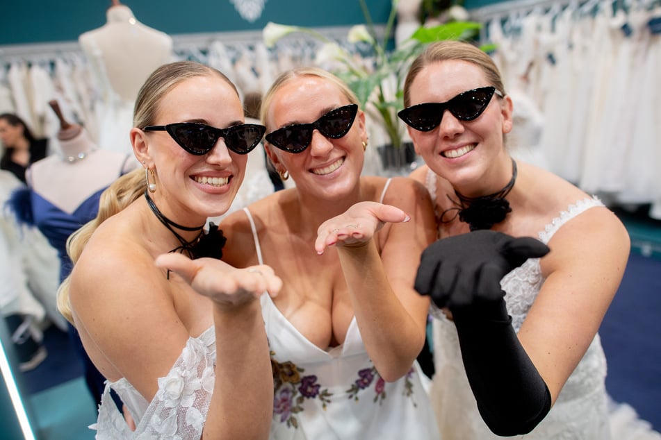 Die Models Henrike (v.l.), Marie und Clara stehen in Hochzeitskleidern an einem Stand auf der Hochzeitsmesse in Oldenburg.