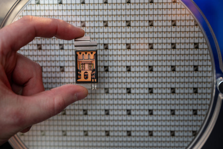 Aus den Wafern, runden Platten aus Silizium (Hintergrund), werden winzige Bauteile für elektronische Geräte geschnitten.