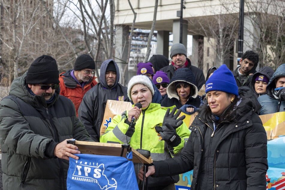 Patricia Carbajal (front c.), Doris Landaverde (front r.), and other members of the Massachusetts TPS Committee speak at a press conference at the John F. Kennedy Federal Building in Boston urging the Biden administration to extend and re-designate TPS for all TPS-designated countries.