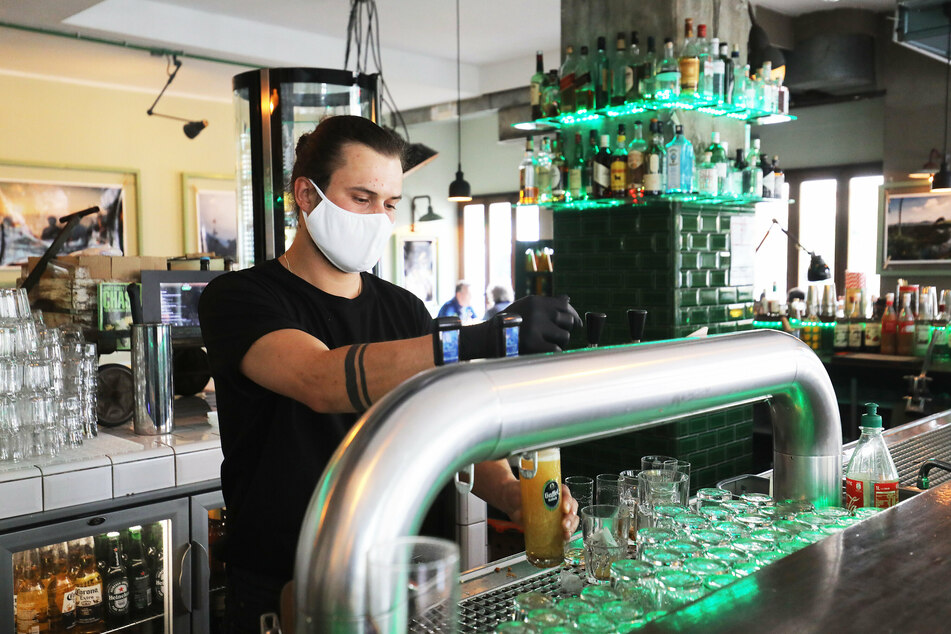 Ein Kellner im Kölner Lokal "Herr Pimok" zapft ein Bier.