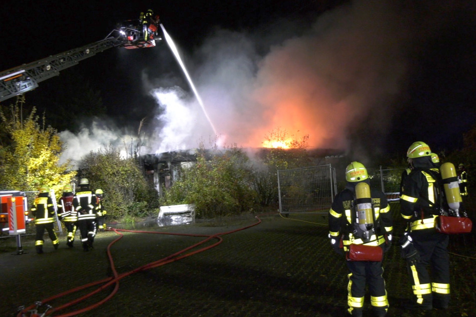 Die Feuerwehr löscht das lichterloh brennende Dach eines ehemaligen Vereinsheims.