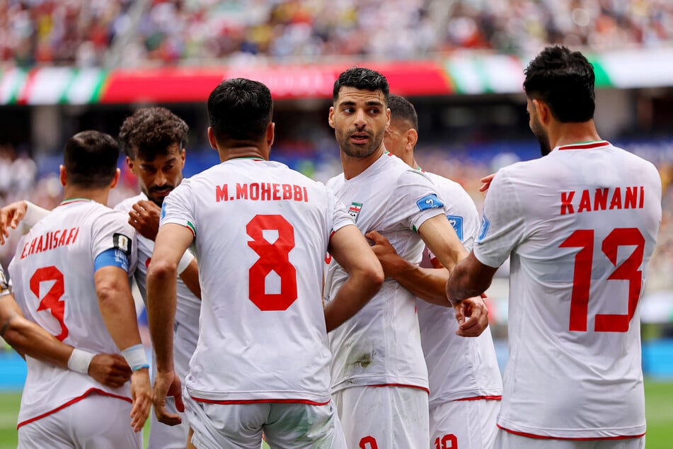 Iran's Mehdi Taremi and his teammates celebrate scoring a goal against Belgium that was later disallowed for offsides on June 21, 2026.