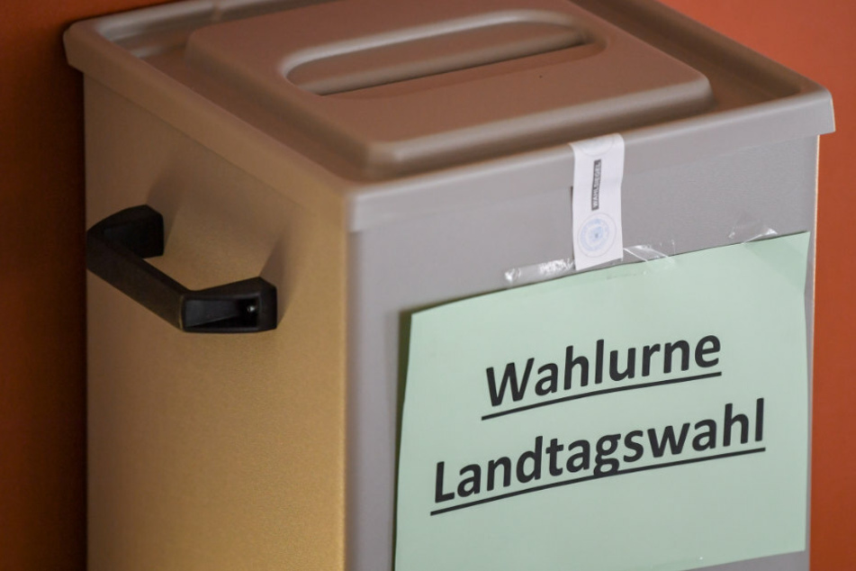 Ein Zettel mit der Aufschrift "Wahlurne Landtagswahl" hängt an einer Wahlurne. (Archivbild)