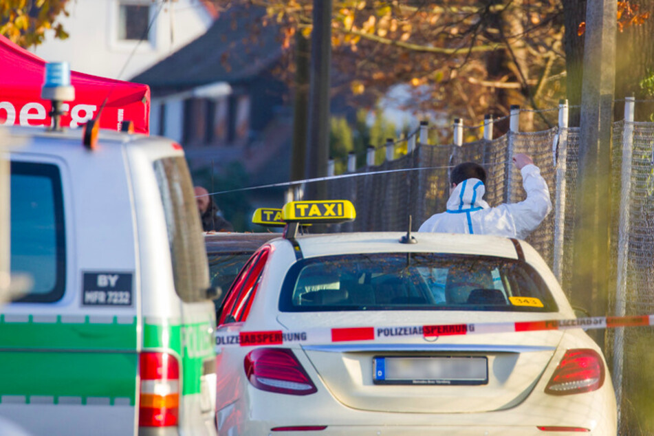 in Mitarbeiter der Spurensicherung arbeitet an einem Tatort auf einer Straße, in der zuvor zwei Menschen erschossen wurden.