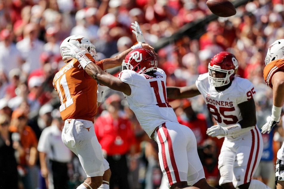 Casey Thompson of the Texas Longhorns throws a pass under pressure by Nik Bonitto of the Oklahoma Sooners in the first half during the 2021 AT&amp;T Red River Showdown at Cotton Bowl.
