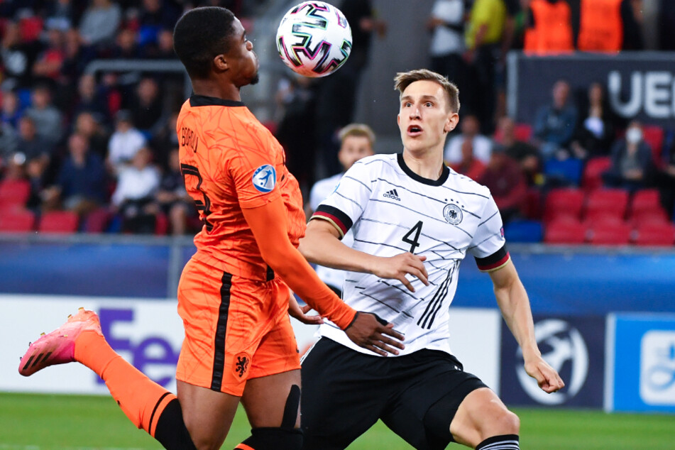 Deutschlands Nico Schlotterbeck (21, r.) und Myron Boadu (20) von den Niederlanden kämpfen im Halbfinale der U21-EM um den Ball.