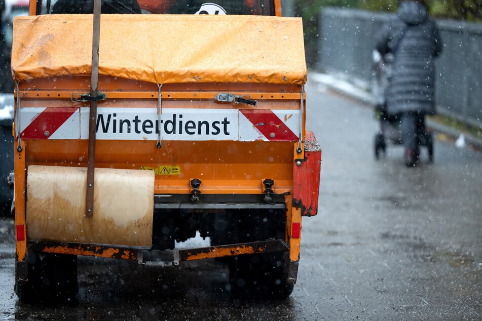 Mitarbeiter des Münchner Winterdiensts verteilen vermehrt Splitt und Salz auf den Straßen und Gehwegen.