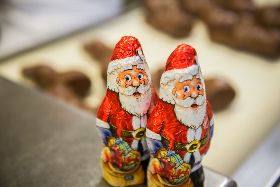 Verpackte Schokoladen-Weihnachtsmänner stehen bei der Schokoladenfabrik Rübezahl auf einer Abdeckung.