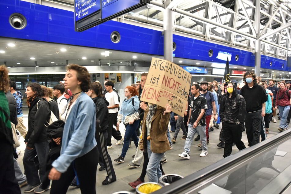Mehr als 200 Menschen protestieren vorab am Flughafen gegen die Abschiebung.