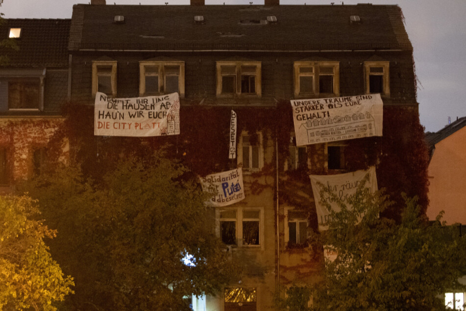 Transparente von Aktivisten hängen an den Fenstern eines leerstehenden Wohnhaus. Mit der Hausbesetzung wollen die Aktivisten eigenen Angaben zufolge gegen steigende Mieten, Zwangsräumungen und Profitinteressen von Immobilienfirmen protestieren.
