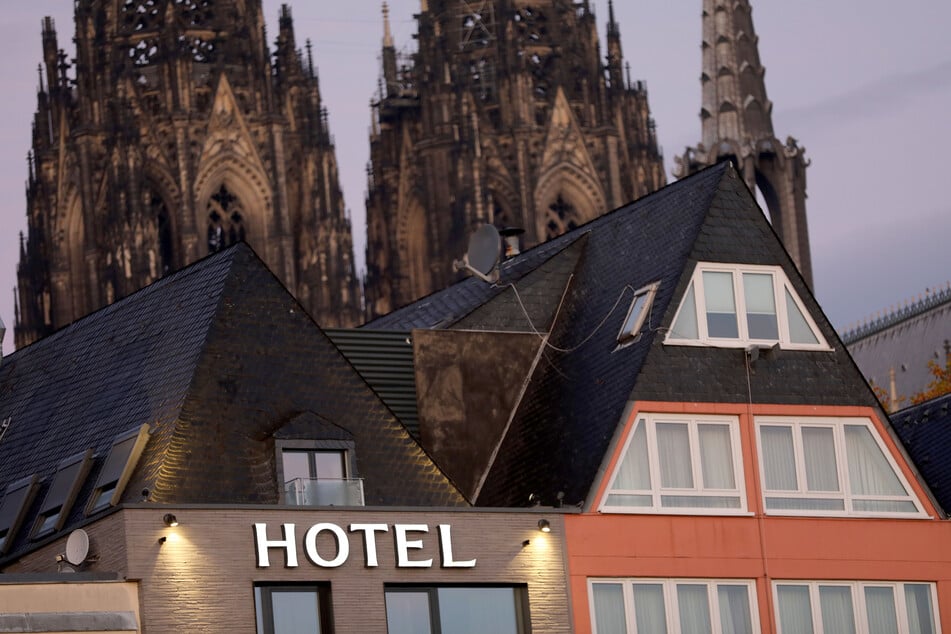 Ein Schriftzug leuchtet am Morgen an einem Hotel in der Nähe des Kölner Domes.