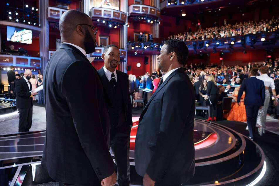 Will Smith is comforted by Denzel Washington (l.) and Tyler Perry following his assault against Chris Rock.