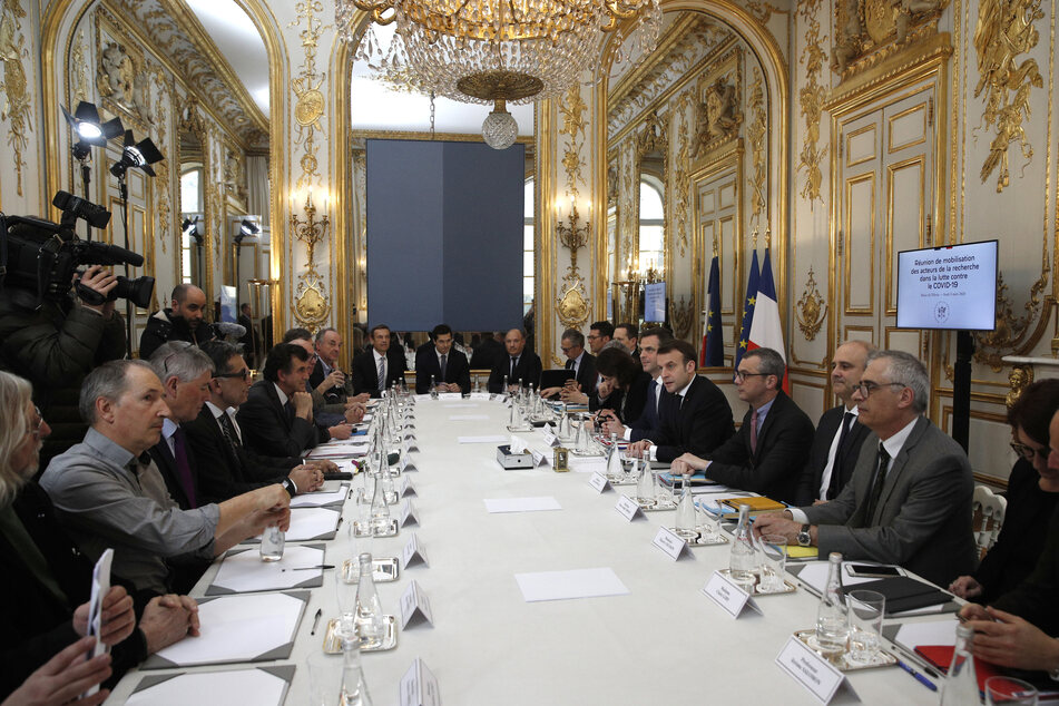 Der französische Präsident Emmanuel Macron (4.v.r) und der Gesundheitsminister Olivier Veran (5.v.r) empfangen angesichts der Coronavirus-Epidemie Wissenschaftler, Forscher und Experten zu einem Arbeitstreffen im Élyséepalast.
