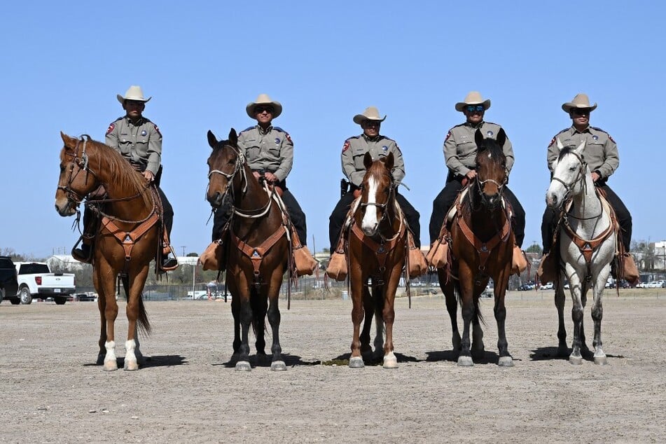 Members of the US Border Patrol listen as Vice President JD Vance speaks to the press as he tours the US-Mexico border at Eagle Pass, Texas.