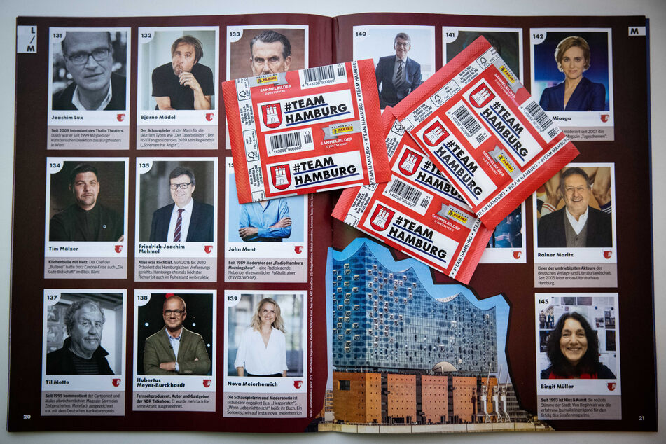 Das neue Panini-Sammelalbum "#Team Hamburg" und drei Tütchen mit Sammelstickern liegen auf einem Tisch.
