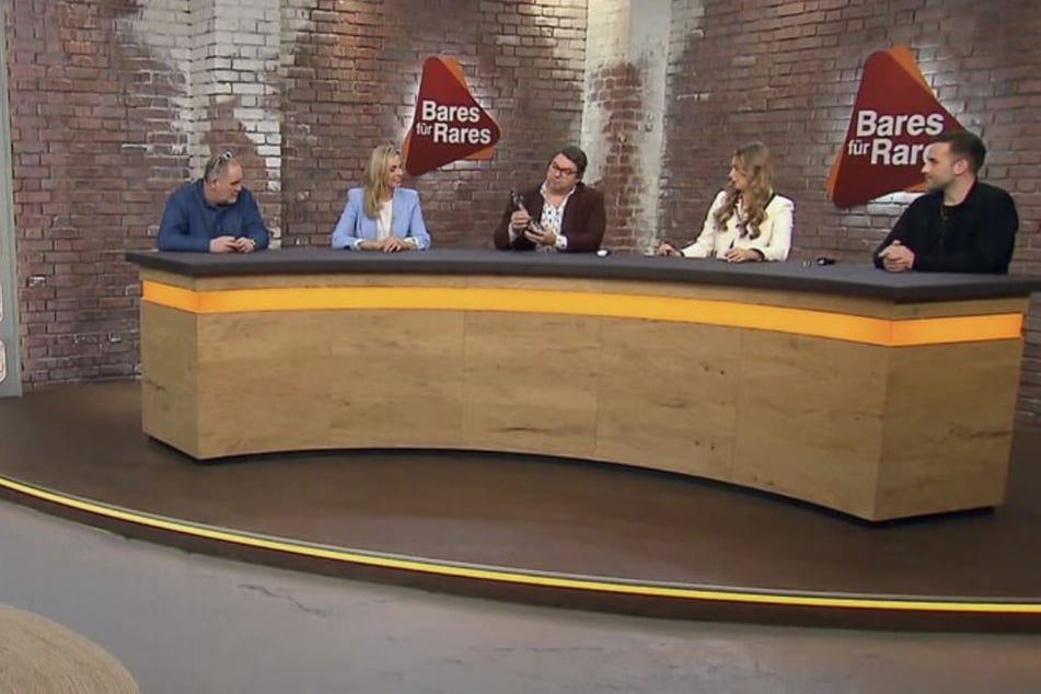 Die Händler im Verkaufsraum sind von dem Kreuz nicht überzeugt.