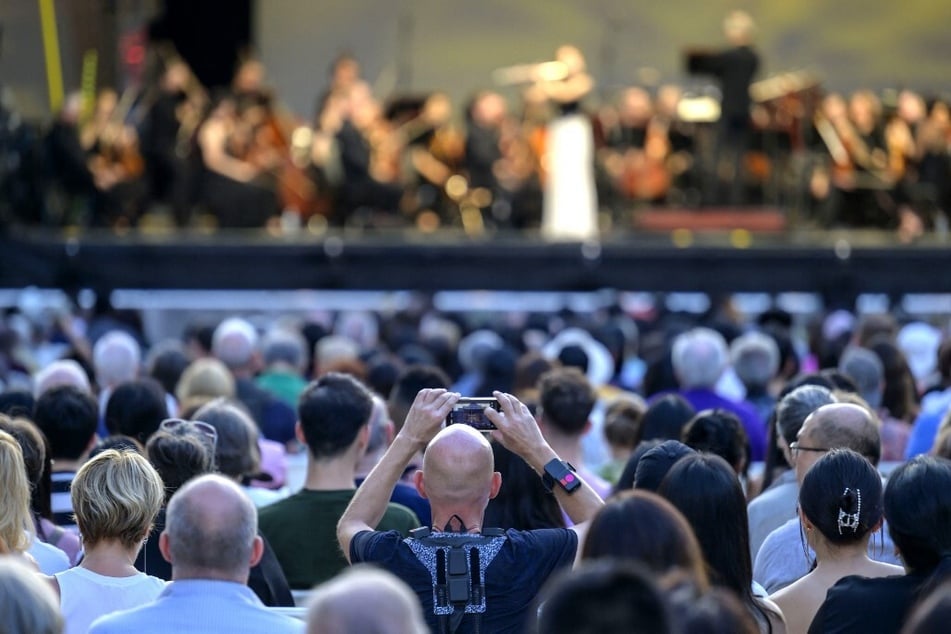 A concertgoer wears a haptic suit created for the deaf by Music: Not Impossible during an outdoor concert at the Lincoln Center.