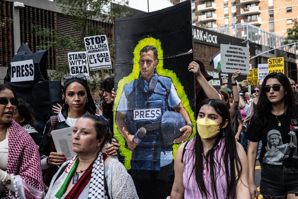 Protesters carry an image of Al Jazeera journalist Anas al-Sharif, who was killed by Israel in Gaza, during a "March for Humanity" on August 16, 2025, in New York City.