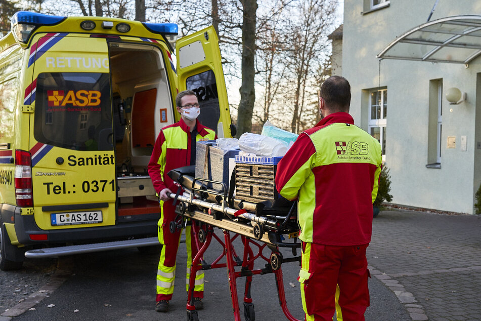 Die Chemnitzer ASB-Mitarbeiter Ben Fleischer (l.) und Christian Homburg transportieren 145 gekühlte Anti-Corona-Impfdosen auf einer Trage zu einem Altenheim.