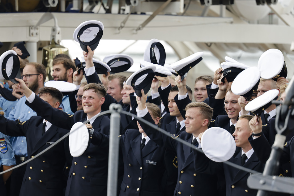 Besatzungsmitglieder der "Gorch Fock" winken während des Auslaufens. Das Segelschulschiff ist am 8. August 2022 zu einer Ausbildungsreise aufgebrochen und wird Ende September im Heimathafen Kiel zurückerwartet.