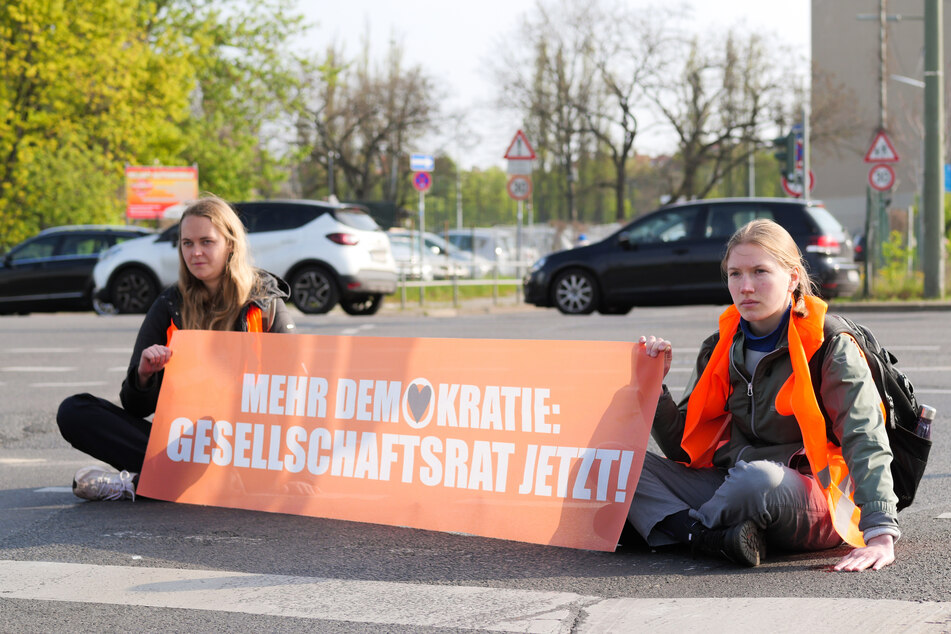 Klimaaktivisten der "Letzten Generation" sitzen auf der Straße in Berlin-Schöneberg.
