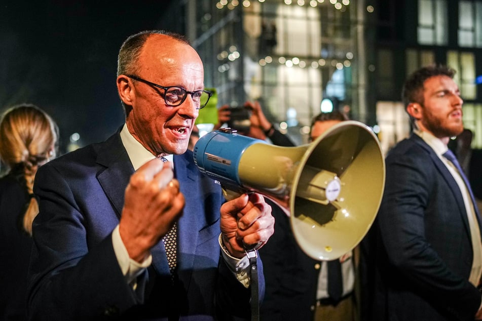 Friedrich Merz (69), Unions-Kanzlerkandidat und CDU-Bundesvorsitzender, spricht durch ein Megaphon bei seiner Ankunft beim TV-Duell von ARD und ZDF am Studio zu seinen Anhängern.