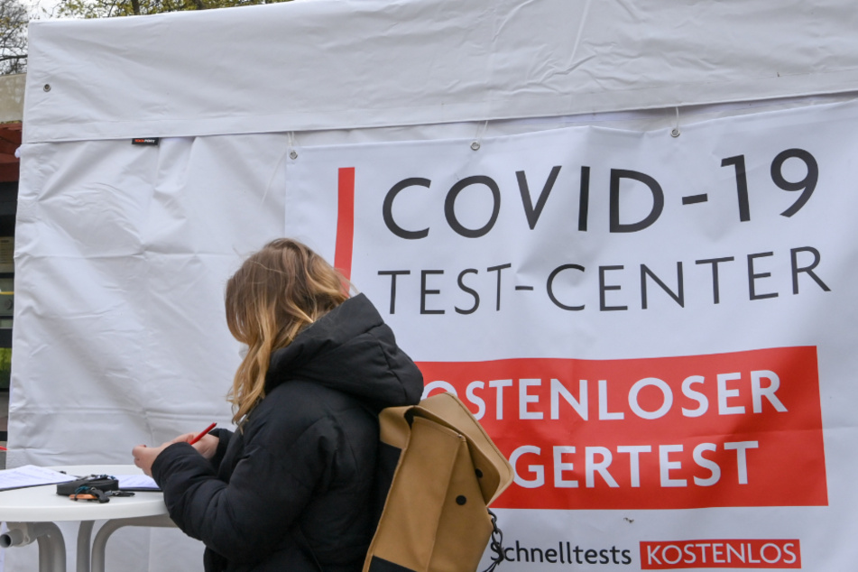 Eine Frau steht vor einem Corona-Testzentrum. (Symbolbild)