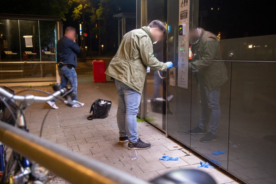 Ein Ermittler sichert Spuren am Tatort an einem WC-Häuschen.