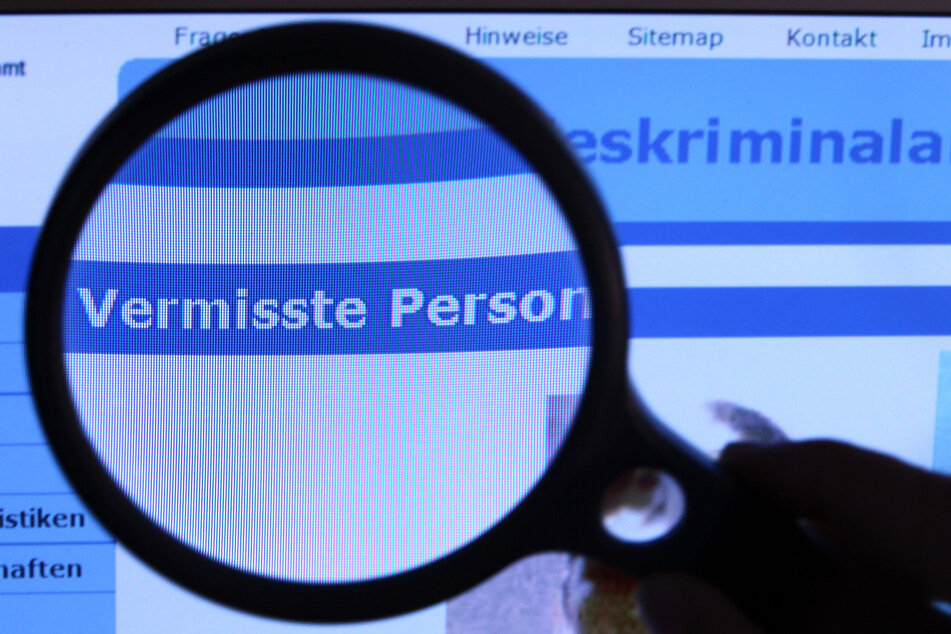 Hinter einer Lupe ist der Schriftzug "Vermisste Person" auf einem Fahndungsaufruf auf der Internetseite des BKA zu sehen. (Illustration)