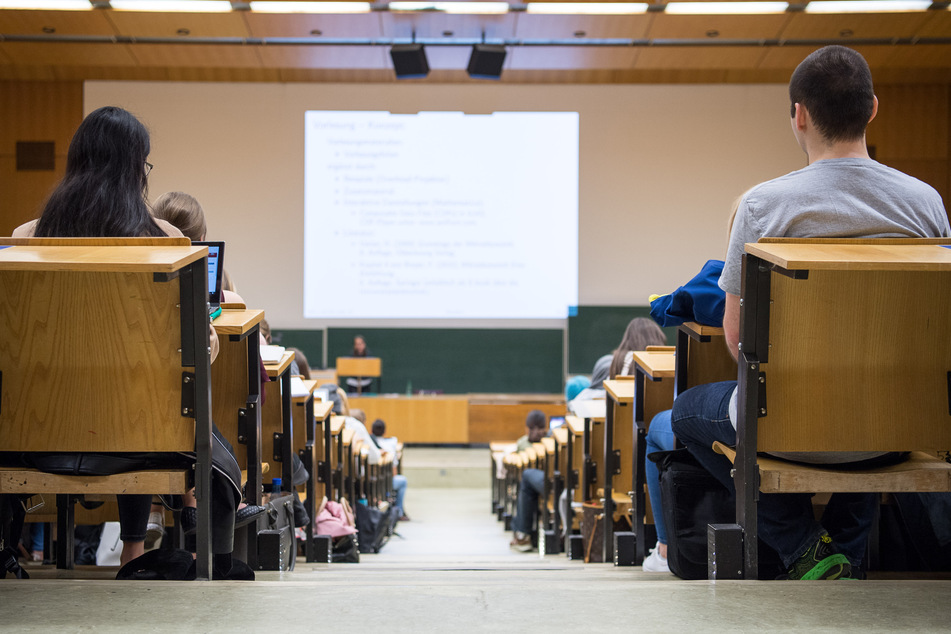 Studenten sitzen während einer Vorlesung in einem Hörsaal.