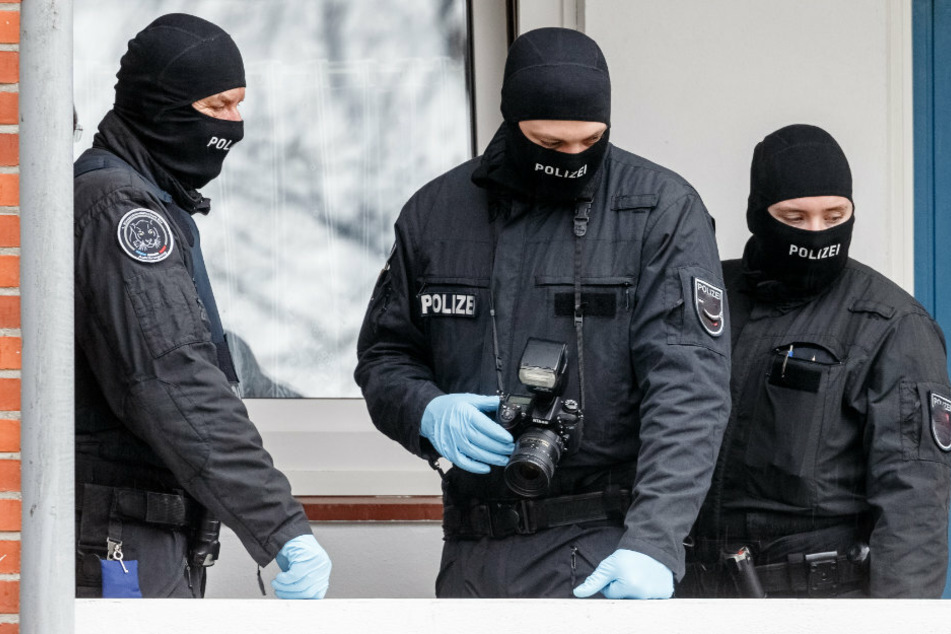 Beamte eines Spezialeinsatzkommando (SEK) der Polizei stehen vor einer Wohnung. (Symbolbild)