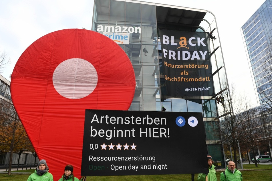 An der deutschen Amazon-Zentrale in München haben Demonstranten Transparent mit der Aufschrift "Black Friday: Naturzerstörung als Geschäftsmodell" montiert.
