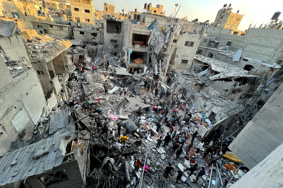 Palestinians search for casualties at the site of Israeli strikes on houses in Jabalia refugee camp at the Indonesian hospital, in the northern Gaza Strip, on November 18, 2023.