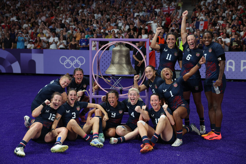 Team USA ring the bell after winning their Olympic rugby sevens quarterfinal match against Great Britain.