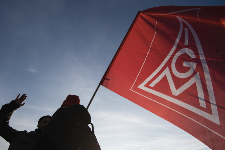 Ein Teilnehmer eines landesweiten Aktionstags der IG Metall im November 2019 hat auf dem Schlossplatz eine IG Metall-Flagge in der Hand.