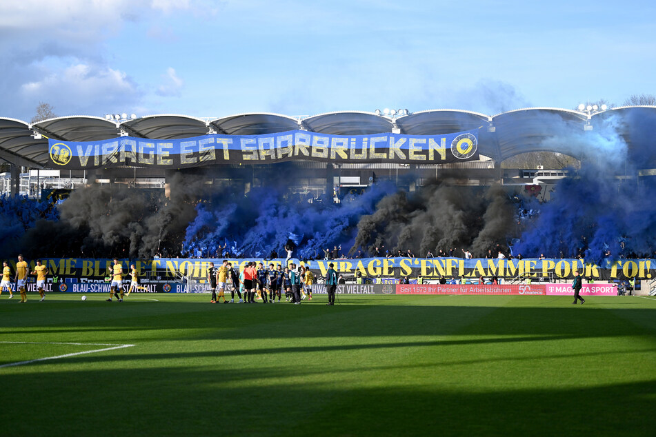 Fans von Saarbrücken zünden zu Beginn der Partie Pyrotechnik.