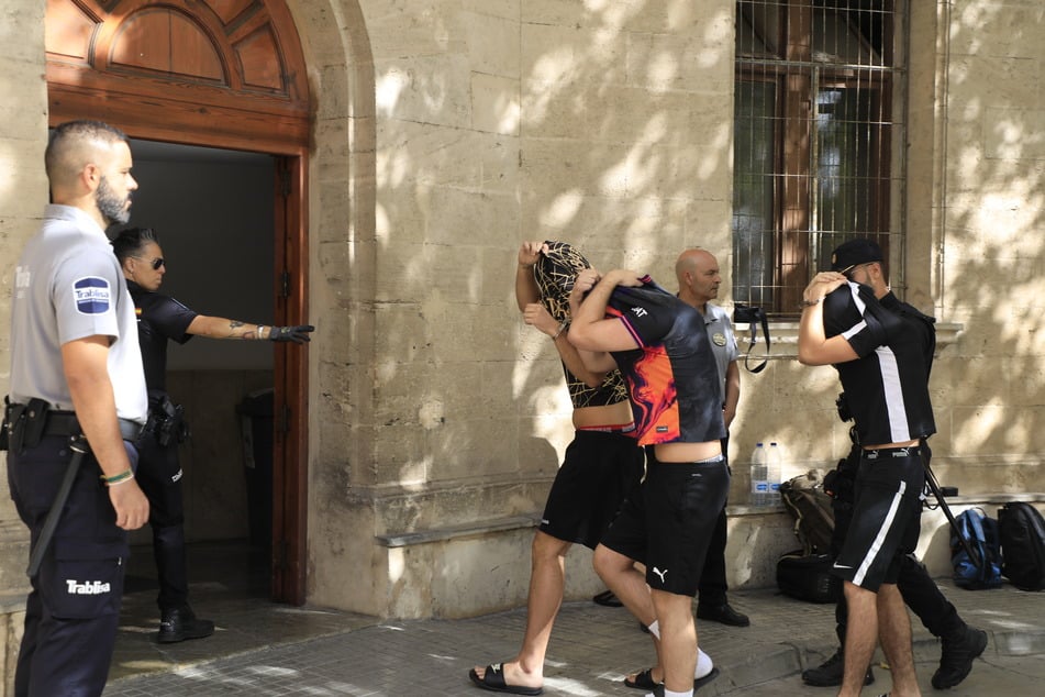 Polizisten führen die Verdächtigen Mitte Juli zum Termin mit dem Haftrichter auf der Balearen-Insel.