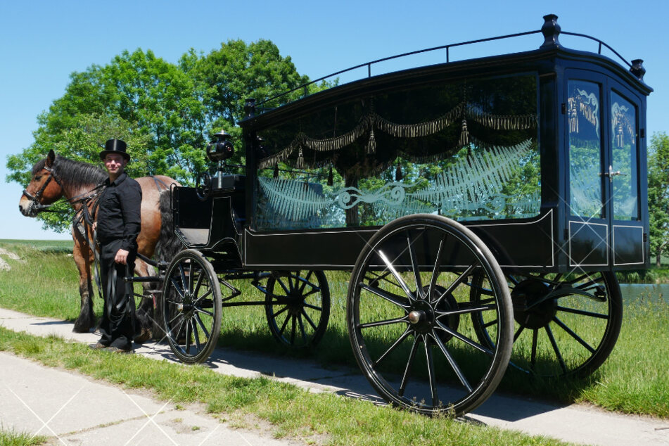 Heute: Mit Zylinder und ganz in Schwarz möchte Dietmar Dietze (38) die Verstorbenen in dieser gläsernen Kutsche zum Friedhof geleiten.