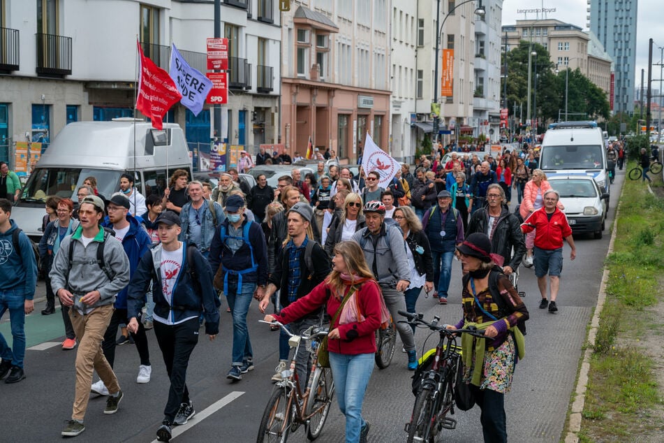 Aus Protest gegen die Corona-Politik wandern Demonstranten durch eine Straße.