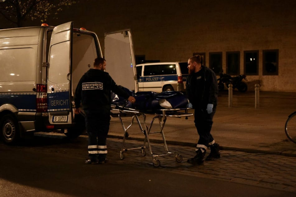 Mitarbeiter der Gerichtsmedizin transportieren die Leiche ab.