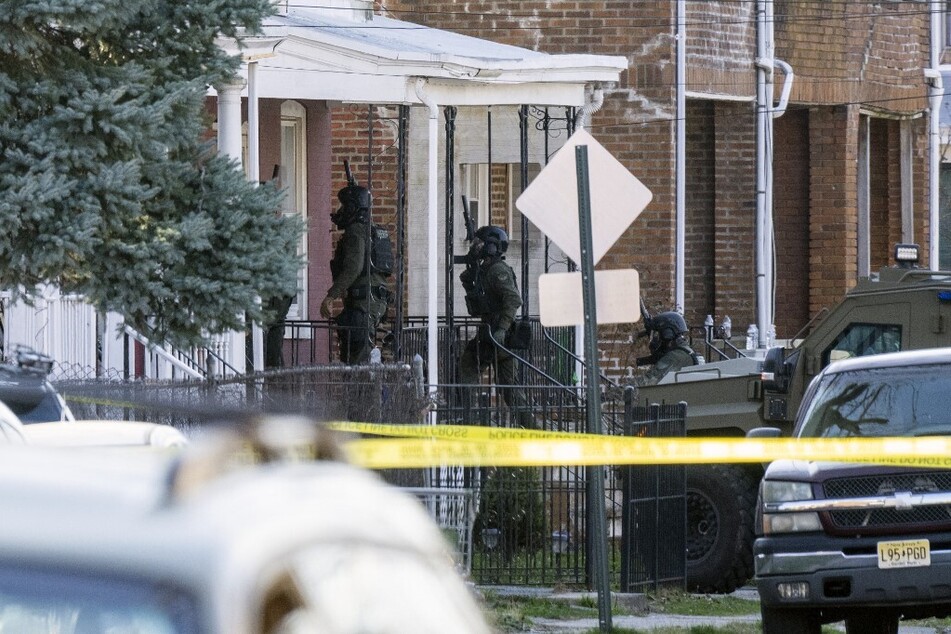 Police enter a home in Trenton, New Jersey, on March 16, 2024, after reports that a gunman, who is suspected of a shooting spree in Pennsylvania, was barricaded inside.