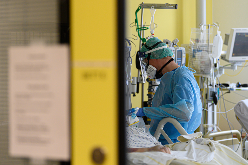 Ein Intensivpfleger kümmert sich auf der Covid-19 Intensivstation (ITS) im Städtischen Klinikum Dresden um die Versorgung von Corona-Patienten.