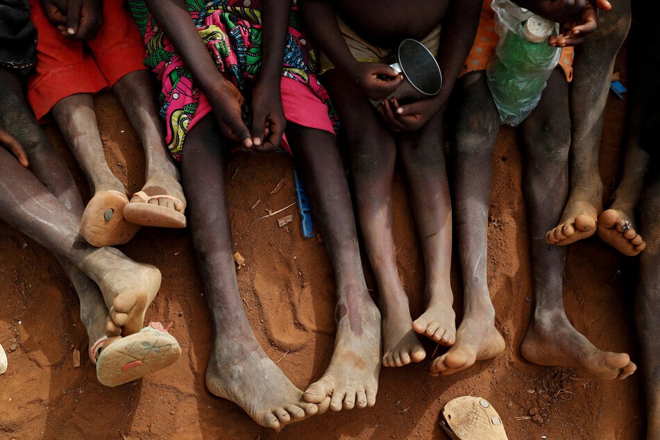 Orphans and children separated from their parents in Kadugli gather to eat boiled leaves at an IDP Camp within the Sudan People's Liberation Movement-North controlled area in Boram County, Nuba Mountains, South Kordofan.