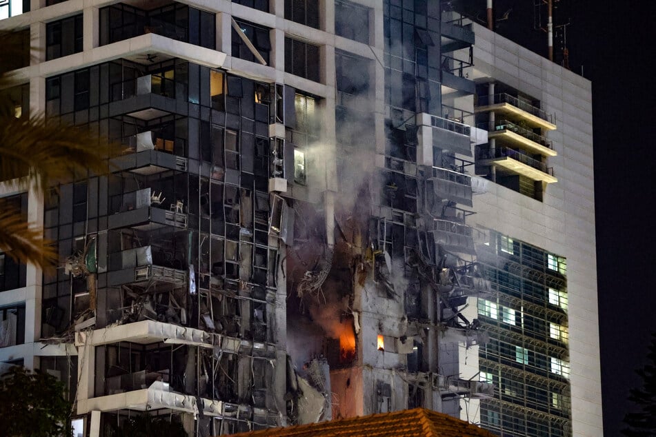 Fire and smoke rise from a building, reportedly hit by a missile fired from Iran, in central Tel Aviv on Friday.