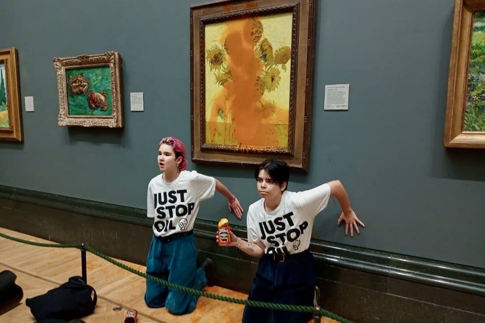 Zwei Mitglieder der Klimaschutz-Gruppe "Just Stop Oil" klebten sich am Freitag mit Sekundenkleber an eine Wand der Nationalgalerie in London. Zuvor hatten sie "Sonnenblumen" von Vincent van Gogh mit Tomatensuppe übergossen.